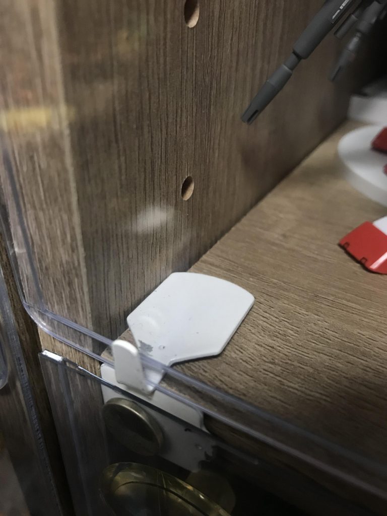 棚の下部3ヶ所に、L字に曲げたフックを貼り付ける事でカードケースがうまく引っかかります。また、カードケースを取り外しやすいように、大きめの吸盤をぺたり。