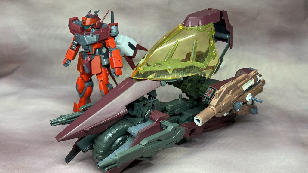 専用ビークルとして製作したバイクです。メテオホッパーを2個とジャンクパーツを使用し、前部と後部の接続にバトルアームズアームを使ってます。前部はメテオホッパーにビルドカスタムパーツを使ってメガ粒子砲を増設。ジャンクにあったフライングアーマーの前方基部を接続してます。後部はジャンクすぎてなんのパーツか分かりませんがソレっぽいパーツを適当にボールデンアームズで接続。バイザーはヴァルヴレイヴから使用してます。