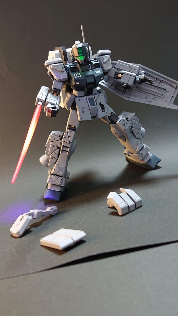 強襲を受けて胸部周りの追加装甲が剥がれた状態。ボックス型のビームサーベルで応戦します!