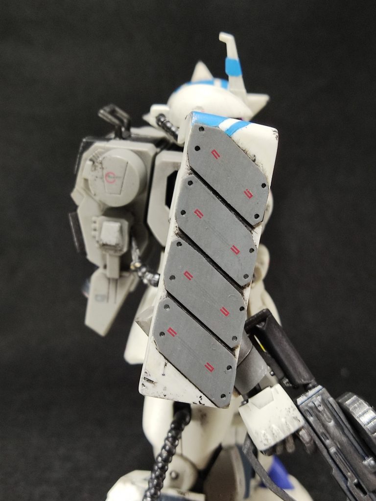 シールドには、ソロモン工廠で試作されたリアクティブ・アーマー・ユニットを装着。ボールや、艦船の実体弾にはともかく、連邦軍MSのビーム兵器には効果がなく、正式採用されずに終わっている。 どっかの作例で見た、「シールドにアップリケアーマー」を真似したモノ。「俺達のマツナガ大尉に、連邦の弾が当たったらどうすんだ!! 」という、マツナガ教の優しさの結晶。単にプラ板ぺたぺたして、四隅に穴開けただけの、簡単工作。ただし、これのせいで「武器をシールドに全部乗せ」という、キットのギミックがなくなる。