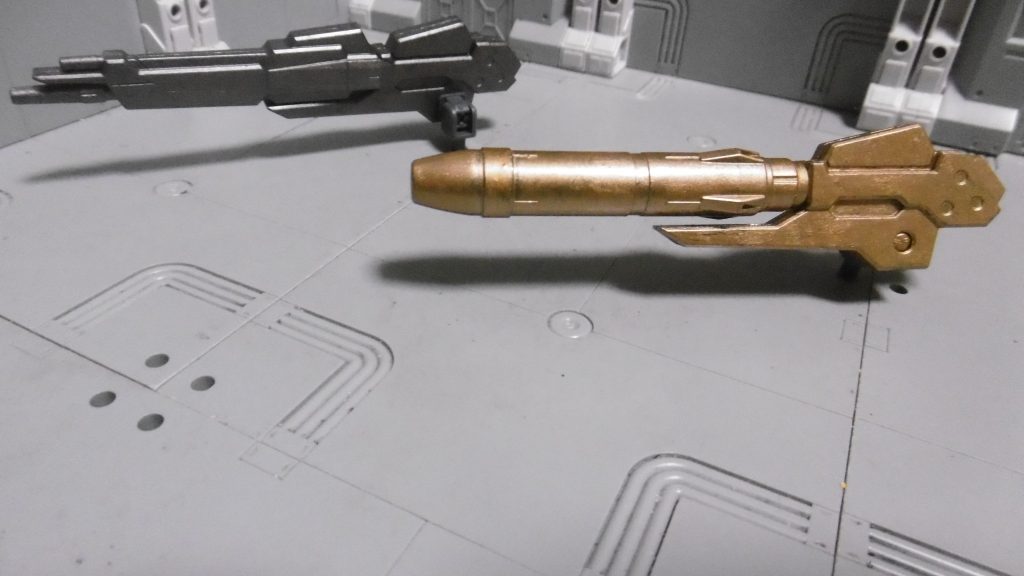 【右肩装備】CWC-LIC/100(リニアガン)【左肩装備】MWM-MDM2/1(2段階分裂マルチミサイル)奥がリニアガン、手前が分裂マルチ(のつもり)4脚最大の特徴「地上でのキャノン発射制限なし」を用いて、リニアガンを主力武器にしました。攻撃力690・弾発熱量870・装弾数100もあり、サイト適性SP(標準と遠距離の中間なサイト範囲)ですが、リロード時間が長いのは厳しめ。適宜ハンドガンに切り替えながら使用。弾反動あり・高い弾発熱量・武器破壊力の高さも魅力ですね。タンクと違い、タンクと強化人間以外では空中でキャノンが使えないため、地上で積極的に狙いたいトコロ。AC世界では距離が離れるほど命中率が落ちるので、最大射程900(FCSでのロック距離700)のリニアガンであっても、近距離メインで使うためOBで接近しつつ、二次ロック最速のFCS補正で高速弾を。対空兵器としても。左肩の分裂マルチミサを選んだ理由は「装弾数2」だけ。右肩武器を積んだ時点で余剰積載量が僅か57しか無く、積むなら撃ちきりパージ戦術しかありません。サイト特性STで最大射程が600(FCS補正ではロック距離460)なら、届けば開幕後に発射または即パージ。これを積んだ状態のままでは重量過多で的にされます。全弾当たれば強いのかもしれませんが、追尾性は高いとは言えず、当たらなくても牽制になればいいや的な「無いよりはマシ」ポジション。仮に大型ミサイルを積む場合、当たれば強力でも、ロックタイム&弾速&リロード時間が遅すぎなのと、ミサイル迎撃システムやデコイといった天敵が多すぎて、使い切るまでに倒される恐れから却下。