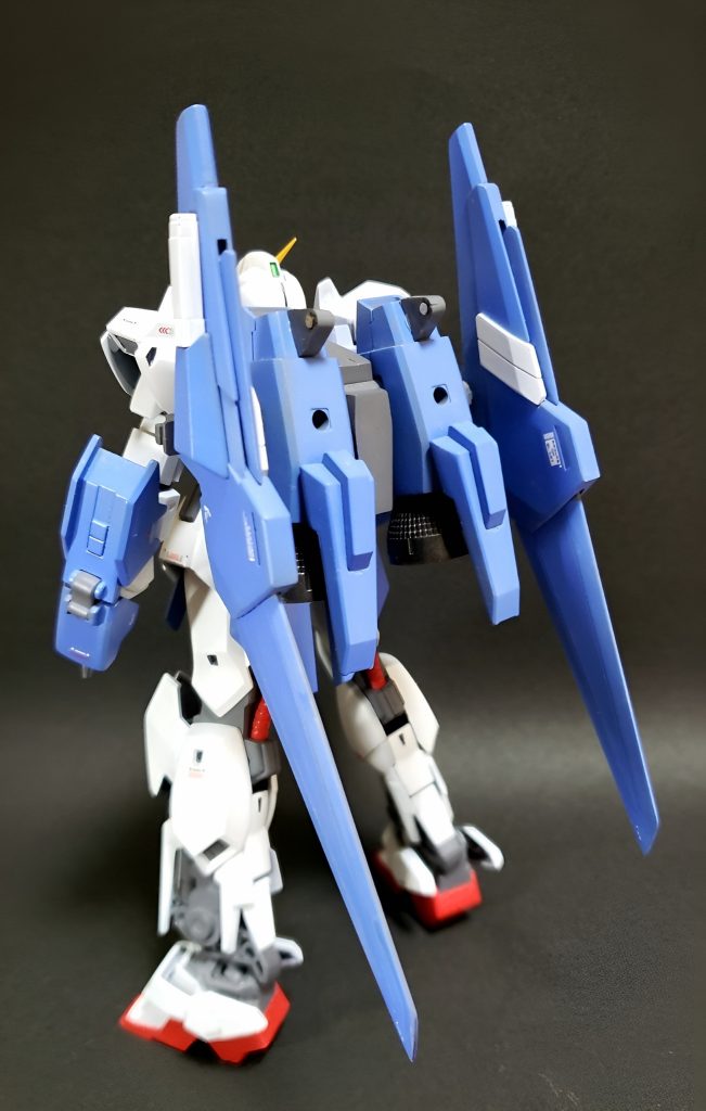 これがビルドΔ(デルタ)ガンダムだ!フロント&バックショット製作イメージはGBNで戦うオレガンダム!本体はほぼ百万式、折れた股関節及び腰回りをキット流用元の百式のジャンクから再度移植するというよく分からないリペアをしています。頭部はゼータ顔に変更し、古箱の隅で見つけた何らかのVアンテナを分割して貼り付けました。百式でもリ・ガズィでもない独特な顔立ちになったかと思います。背中は残ったパーツをかき集め、バインダーのようなものを形成することに成功しました。ポリキャップで接続できたので本体に追従するように動かせます。凸部分には後述の武装が、3ミリ穴はさらに何か付け足せないかと空けたままです。全体をそこそこに均したあと、グランプリとmsホワイトで塗り、増加装甲部にmsライトブルー、関節と武器に連邦グレー、パイプ部とゲタにRXレッドを塗り重ねています。ビルドガンマガンダムの色が好きなこともあり、並び立ちが似合うような淡めの色合いを目指しました。かなり目が奥まってしまって見えづらいですがセンサー部分にはラピーテープを。