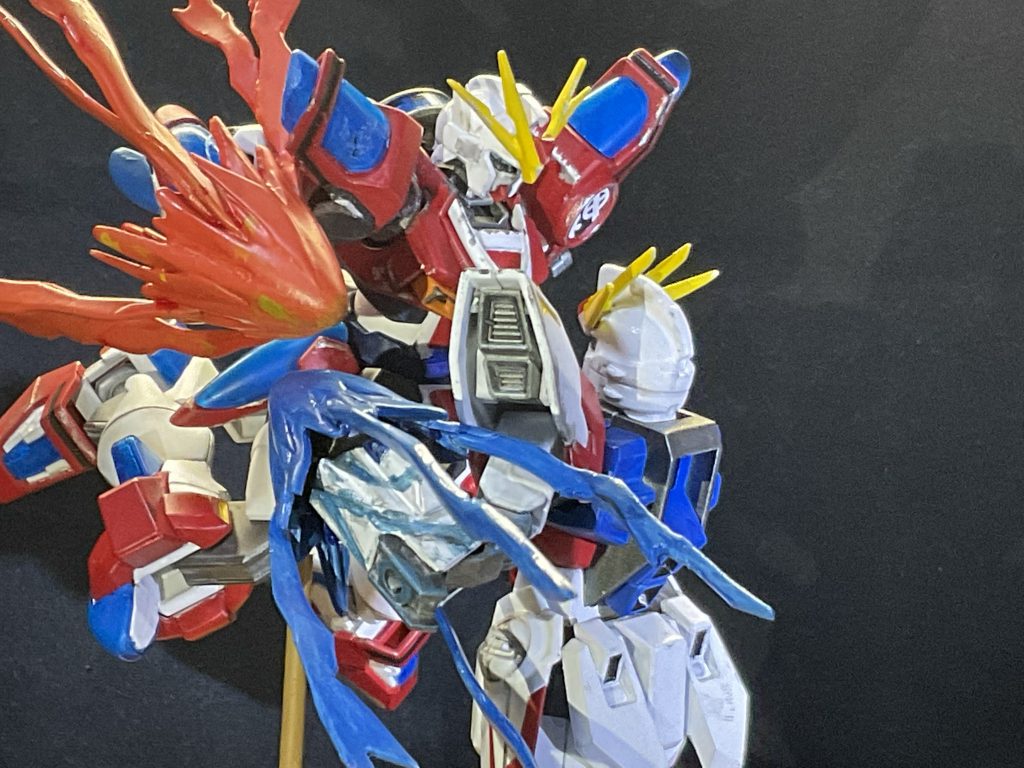 カミキバーニングは上から飛び掛かるようなポージングで。右肩のクリスタルに穴をあけて損傷を表現してます。ビルドストライクの右腕はボロボロにして、ビルドナックルの発光が傷から漏れ出ているイメージで塗装。同様にカミキの右腕のクリスタルもひび割れさせています。ナックルのエフェクトはカミキに両腕分付属していたので使用。炎の本数を増やしたり、先を尖らせて稲妻っぽいエフェクトにしてみました。