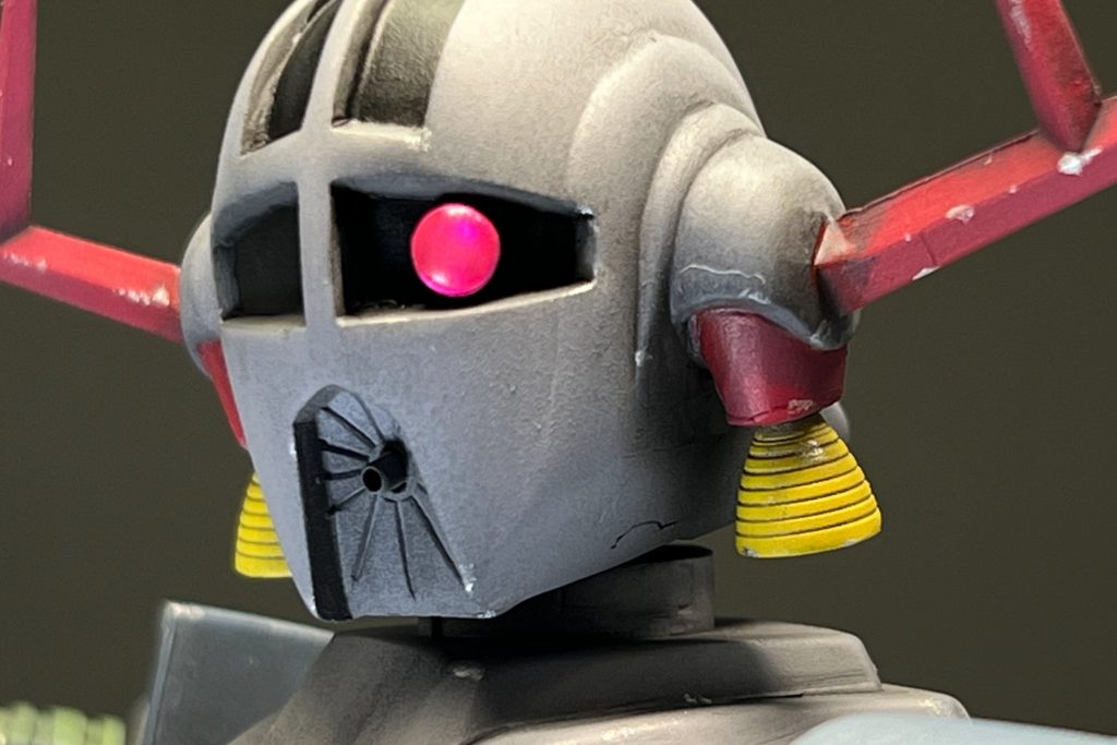 頭部は両端のツノをシャープ化しつつ、首元に違和感を覚えたのでフェイスラインを削り小顔化。スラスターも別パーツに置き換えて、メガ粒子砲はメタルパーツに換装です。そして、モノアイにも仕掛けがありまして…、