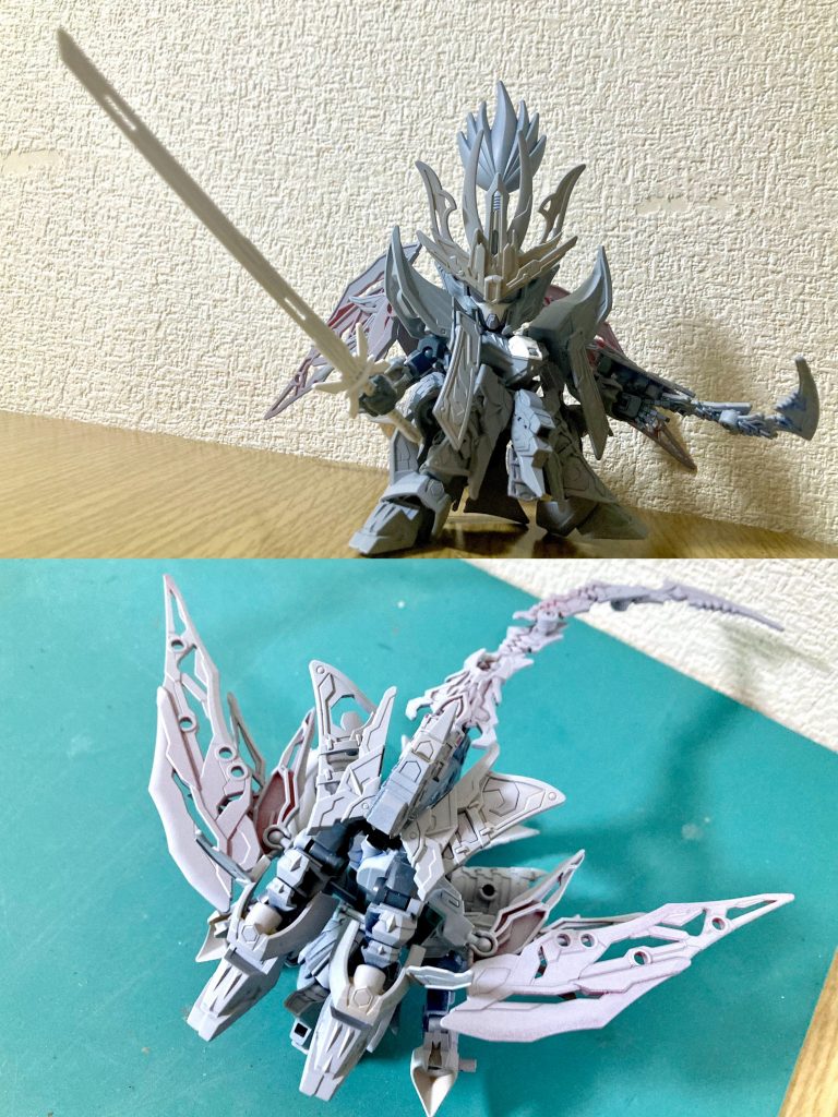 信長エピオンをベースに、前立や直垂など特徴的な装飾は倚聖の装を、背部バインダーには司馬懿デスティニーの羽根を一部整形してエピオンのウイングっぽく接続しました。エピオンの大胆なアクションポーズを少しでも再現出来るよう、全身にボールデンアームアームズを用いた可動改修を満載しています。その際、先駆者SDモデラーの方々が考案・公開されている技術を大いに参考にさせて頂きました。先達の叡智に心から感謝と敬意を表させて頂きます。元MSのエピオンらしさという点で是非とも変形機構も再現したいと思っていましたが、上述の可動範囲向上の副次的効果で割とスムーズに変形モードを実装する事が出来ました。SD頭身で機体をそのまま折り返すだけでは実現不可だったため、ガンプラバトルアームアームズで構成した変形用の差し替えパーツを間に挟み、見映え重視で各パーツを取り付ける方法で再現しました。