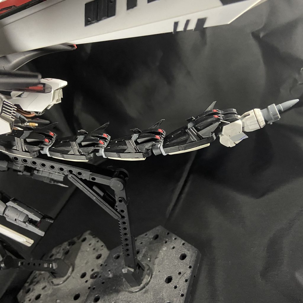 後方に伸びる尻尾のようなユニットはまたもやビット兵器です。シェヘラザードのプトレマイオスアームズをボールデンで連結しました。これは一つ一つに分離し相手を追跡する爆弾になります。ファンネルミサイルのようなものです。そしてこれは資材がある限り機体内部で製造されます。しかし先端の1つだけはダインスレイブもどきを発射する機能があるので製造できません。