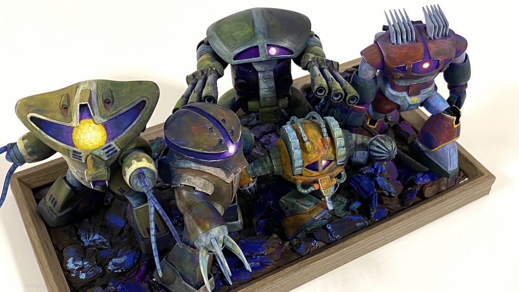 ジオラマベースはフォトフレームを使用。インテリアバークと紙粘土で地面を作り、黒サフと茶サフを吹いてからアクリルガッシュで色付け。ジャブロー風にしてみました。