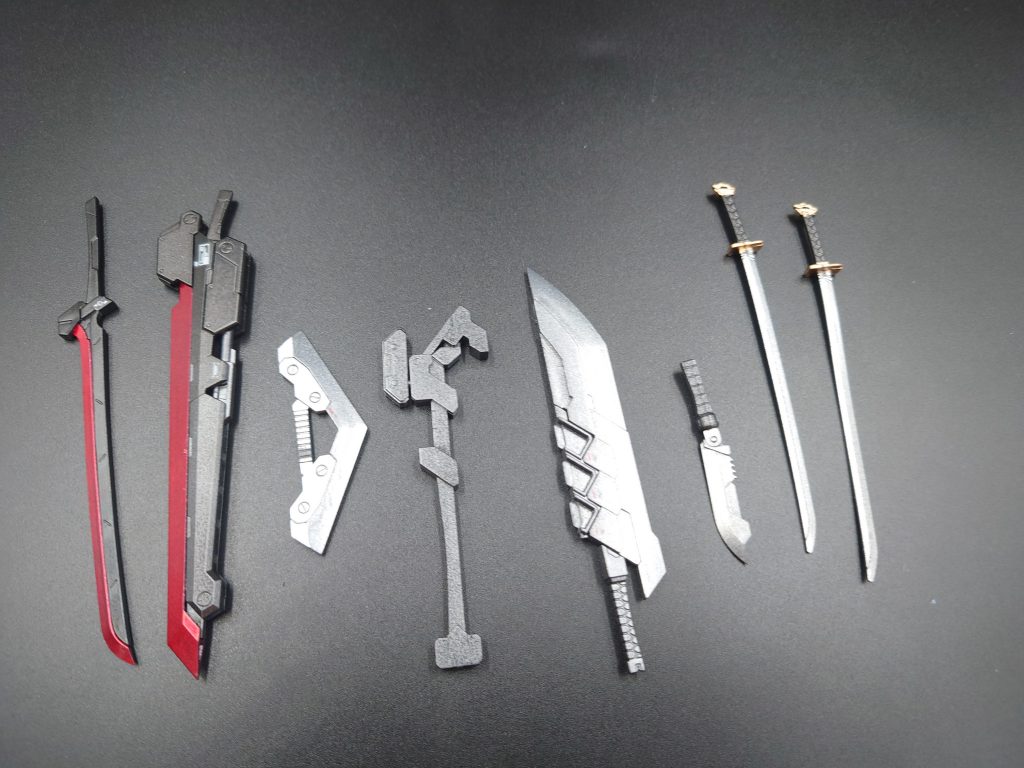 搭載武装たちをばらして並べた写真です。通常のHGの手だと持てないので持ち手をヤスリで削りました。アックスの持ち手がこう見ると削り方が雑ですね…
