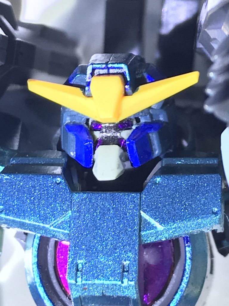 ELS戦役終結後に連邦平和維持軍の次世代MS開発チームが連邦政府の運営する複数の研究所と合同で建造した試作機。「アヘッド」「トリロバイト」「ブレイブ」に続くGN-Xシリーズとは別系統の新型機建造を目的に製造されたが、一応の完成を見た手足はともかくGNドライブ周辺機器(胴体)については著しく設計へのノウハウが不足しており、結局胴体はGN-Xと殆ど同じ設計になってしまった。しかし、その周辺機器の小型化には成功ししていた為コックピットの位置は従来のGN-Xタイプと異なりガンダムと同じ胸部に変更されている。(擬似太陽炉搭載機の中ではガンダムスローネで既に胸部コックピットは実現しているが……)