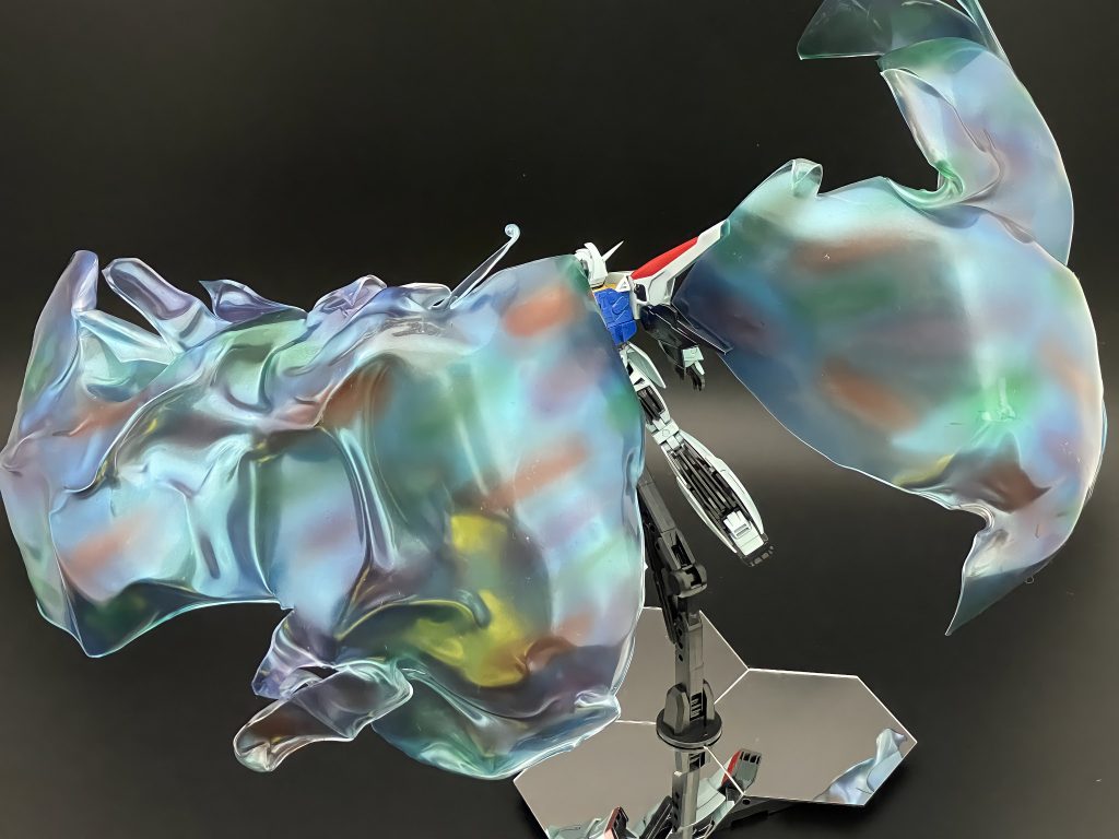 月光蝶の塗装手順はクリアレッド、グリーン、パープルをそれぞれ楕円形に散らす↓クリアブルーに変更塗料(クレオスサファイアブルー、ガイアプリズムメタリックターコイズグリーンメタリックブルー)を混ぜたもので全体を塗装という手順。実物はもうちょっと透けてますが、写真だとシャボン液のようにも見えますね。