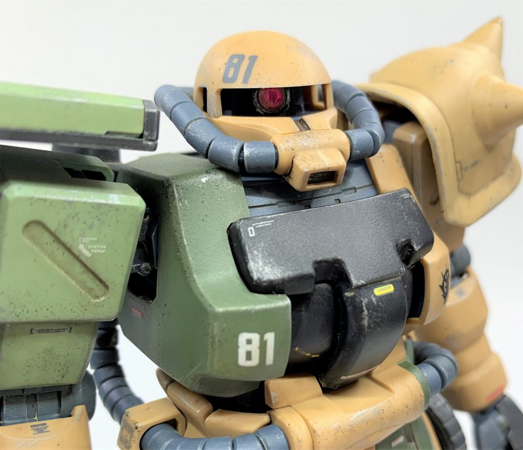 モノアイは元々ある接続軸を切り飛ばしビルダーズパーツのMSサイトレンズのベースを接着、中にメタリックシールを貼りレンズを嵌めてあります。メカっぽいディテールが欲しい時は基本MSサイトレンズを使っています。シンプルに仕上げたい時は、ウェーブのフラットバーニア+Hアイズで同様の工作をするようにしています。モノアイ置き換え工作は手軽ですがかなり効果的で、ジオン系MSでは屈指のコスパを誇る工作だと思います。特に素組みがシールだけで済ませるようなキットに行うと劇的にカッコ良くなりますよね。