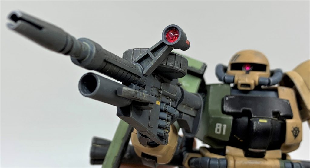 バズーカとマシンガンのレンズは成形色が透明だったのでタミヤのクリアレッドスプレーで塗装し、裏側にメタリックシールをあてがい光の反射を強くしました。クリアレッドはかなり遠目から「こんなんで塗料乗るの？」くらい薄く吹く事を意識すると上手い具合に塗れました。全体的に艶消しの質感の中で、レンズがキラッと光るのはメリハリが効いていて好きです。射撃精度を司る戦闘力に直結する重要な部位ですので、レンズ周りは常に重点的に清掃メンテして性能を保っていたと思います。レンズ部は汚しや艶消しクリア等の工程を全部終わらせてから組んでいます。