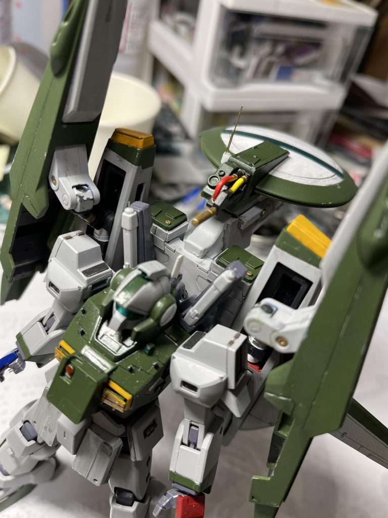 「班長、ND02の次の任務用データプローブなんですが・・・」「お前、コイツの事をいつも機体番号や形式で呼ぶがな。ちゃんとコイツには『彩雲』って良い名前があるんだ。そう呼んでやってくれよ」「俺、なんかそういうの苦手なんスよ・・・。んで、この『彩雲』ってどういう意味なんです？」　彩雲、ご存知帝国海軍の傑作哨戒機からのネーミングです。なので機体色は中島系濃緑色のMrカラー129番を使用しています。　頭部もフェイス部分を鋭角に、ヘルメット部分も大幅に造形しなおし耳のダクトを大型化。実戦機ではないので頭部バルカンは廃止。左後頭部に多目的センサーアンテナを装備。このあたりは1号機の設定を参考に近づけてあります。　肩、胸のパネルラインを彫りプラ板、メタルテープ等でディテールアップ。解像度を上げることを目標としました。胸にはブレードアンテナや追加センサーユニットなどを設置。センチネル系の機体のスジボリを真似て入れてみました。　バックパックにある緑色のハッチの付いた箱はミサイルポッドではなく、偵察用プローブやドローンを収納しているコンテナです。偵察任務の種類によって各種装備変更をします。 