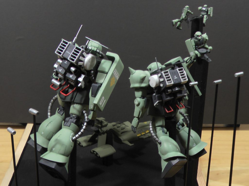 MGとファーストグレードの本体はご覧の通りそっくりなつくりです。背後にいるたくさんのザクは、森永チョコスナックのおまけ(1/300)、ガンダム情景模型のおまけ(1/550)、旧キットガウのおまけ(1/1200)を箱絵に合わせて配置しています。