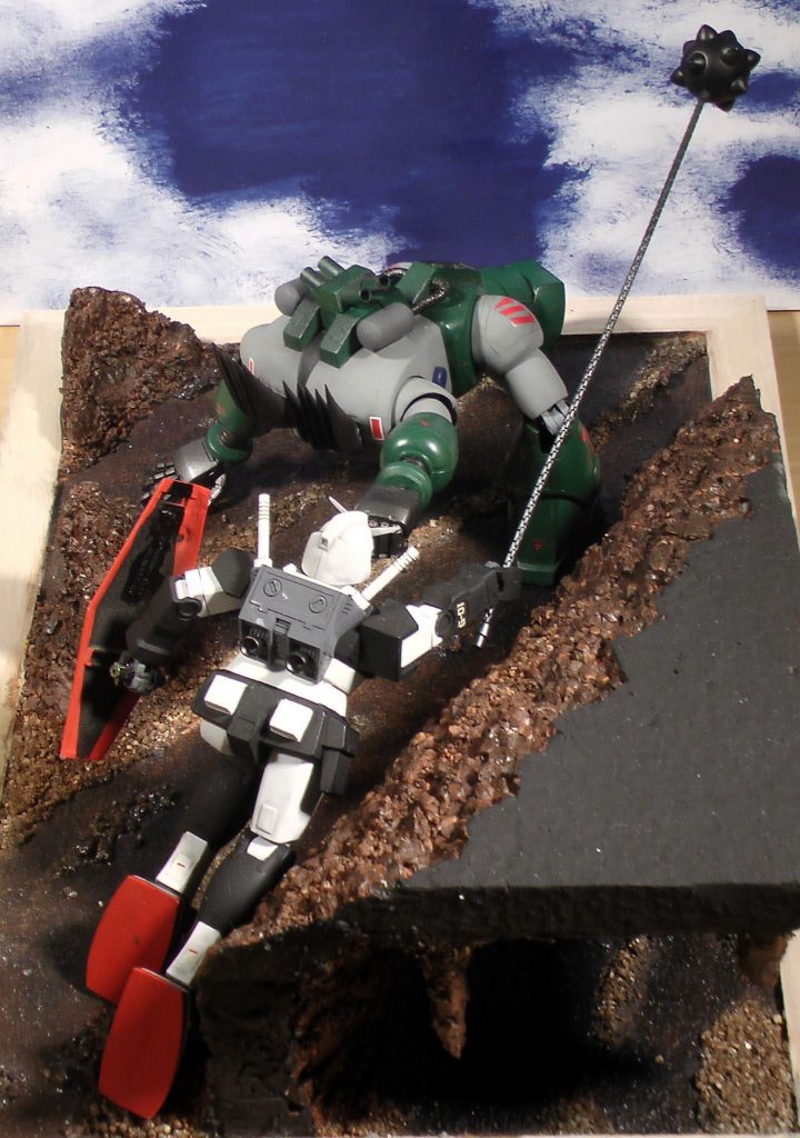 プロトタイプガンダムは、ビームライフルの調整が間に合わず、慣れないガンダムハンマーで苦戦を強いられています。手前にはもう一つの洞窟があります。