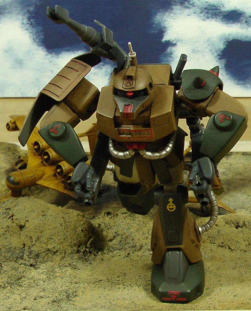 旧キット1/144ザクキャノンのスカートをやや開いて左足を前に出せるようにしています。両手は次元ビルドナックルズ丸の平手を切り刻んでビッグガンを構えさせています。