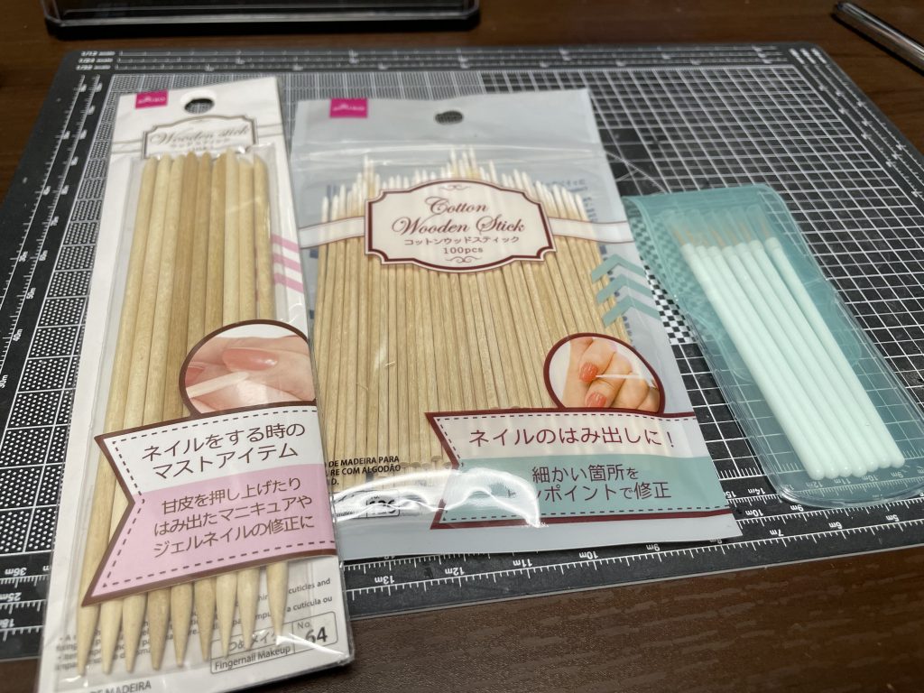 各種用具。左、ウッドスティック先端にペーパー貼って合わせ目消す際に使用。Twitterでバズってたの真似しました。中央、エナメル拭き取りに使用。メタリックは少し残るかも。タミヤの綿棒が間違いないです。右、ネイル筆。メインの塗装具。筆先を少し都合のいいようにカットして使いました。使い捨て感覚でいけます。全てダイソーで。なんと各100円（別）