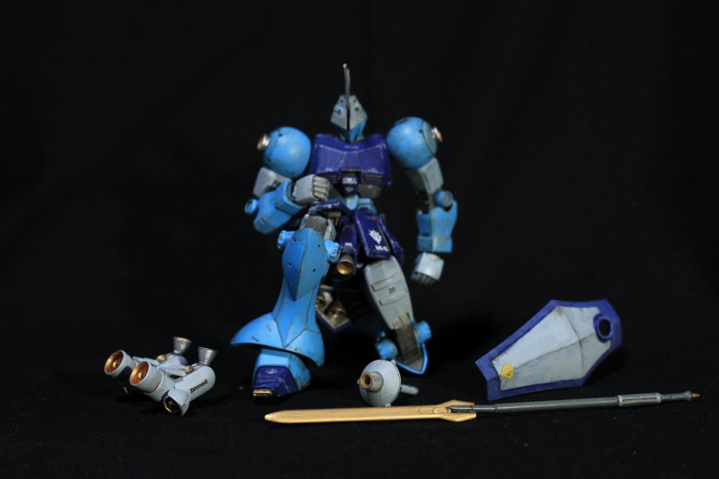 塗装と武装基本はグフっぽい色にしたいと思ってグフカラーで攻めました。むしろB3似(グフカス)。上腕や太腿は元々似ているゲルググ風味のカラーにすることで流用感を出し……たつもり!ゲルググのグレーってもっと濃いか?特筆無き場合Mr.カラーです。薄い青:323 ライトブルーにホワイト10%くらい濃い青:UG17ティターンズブルーグレー部:ガイア ニュートラルグレーⅡ(大好き)関節:32 軍艦色2+120 RLM80フィールドグリーン少し銀:ガンダムマーカーEX シャインシルバー金:9 ゴールドグフシールドの明るいところ:308 グレーFS36375ウェザリングとスミ入れ:シタデル アバドンブラックを水和したものとMr.ウェザリングカラーグレイッシュブラウン リアルタッチマーカーグレー2連邦系連作した時にバーニアをテカった銀にしたので、こっちはバーニア内はゴールドで攻めます。かつてはバーニアといえば黒鉄色で中は赤!と思ってたのですが、実際の宇宙機器とかみてるとやっぱ摩擦とかを考慮して金を使ってたりするので、フレッシュなメタリック感のある塗りのほうがメリハリがつくんですよね。装甲部のつや消しとのバランス。モノアイにはいつものプラ棒にマニキュアをやっていますが、ホリが深すぎて今回ばかりは全く目立たないですね……。