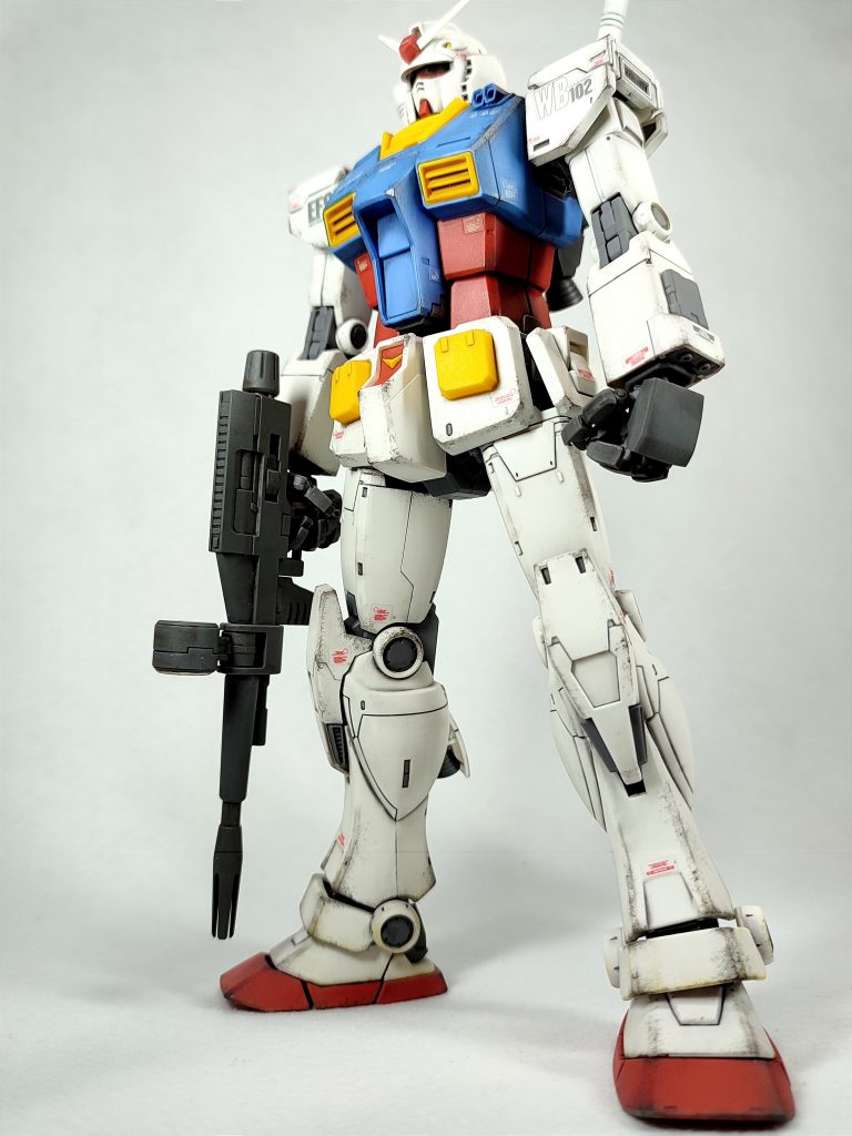 全体像全体組み上げクリアーコートの後、ガンダムマーカーのリアルタッチグレー2で白い部分、青い部分。グレー3でフレーム部。イエロー1とブラウン1でそれぞれ黄色部と赤い部分をウォッシングぽくしてみました。水性カラーの焼鉄色と脚部を中心にウェザリングマスターのサンドでウェザリングを行い、ウェザリングマスターのスノーで胸部とランドセルにハイライトを入れて完成させています。最後にもう一度クリアーコートしたら残念ながらウェザリングマスターは少し消えてしまいました。こういう時もあります…。まぁ良いでしょう…。