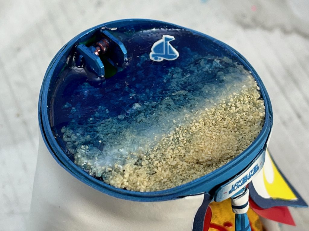 海はレジンと本物の砂で制作。色味の違う青色レジンを何層にも重ねて海の深さを表現。波打ち際は白を混ぜたレジンで泡の感じを狙ってみました。