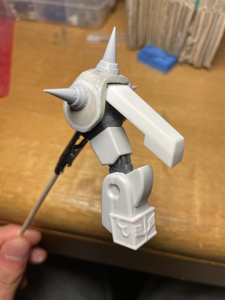 腕部：右肩シールドはほぼそのまま。左肩スパイクアーマーはHG旧ザクの肩にパテ盛り付けて硬化後取り外し、プラ板とパテで補強形状出し。腕関節は前作のゲルググfsと同じように二重関節化。袖は0.5のプラ板で基部を作り、0.3のプラ板でエングレービングを貼りました。