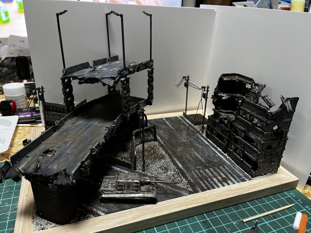 ジオラマはビルと高速道路がセットになってるやつを買ってきて汚しを入れたり半田で壊したり。道路はコルクシートから作りました。戦車は中華製の戦車が同スケールで売ってたので作成。ダボ穴のないプラモ初体験でした。