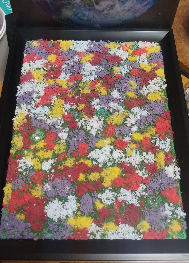 知識がなかったもので、重曹に絵の具を混ぜて花畑の作成。ガンダムと武器の場所を決めてLEDライトを仕込み。透明のアクリルを引いて透明のレジンを流し濃い青と薄い青のレジンで水の感じを作りました。