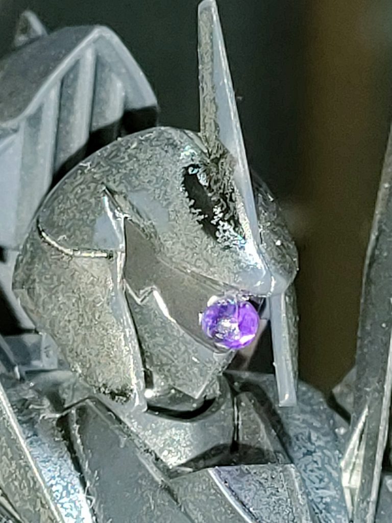 頭部。ラインアイの筈が、紫に光るモノアイとなる。アルスコアガンダムのビームサーベルランナーの切れ端を接着して再現。