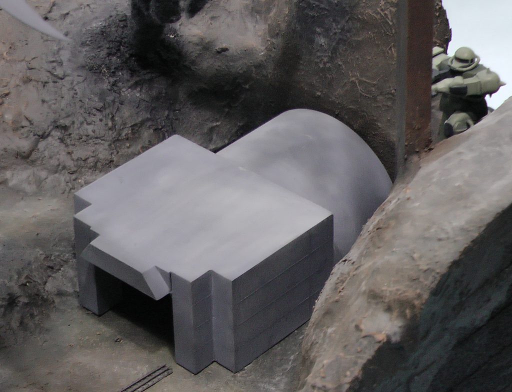 ノリス達のMSがこの後退避するエレベーターの建屋は、手前の線路ともどもプラ板・プラ棒製です。遠近法が効いていますので、約1/400スケールです。