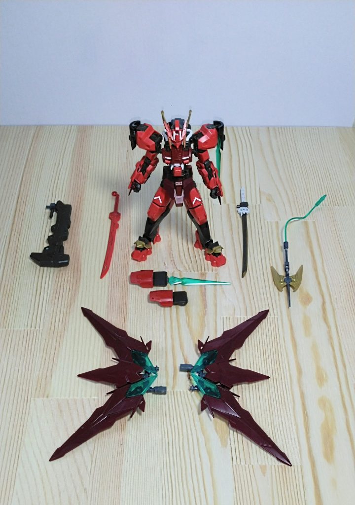 武器を外した姿です。画面中央の本体から、左側の太刀が前述した「天照」とハンマーが「天岩戸」です。機体右側にある太刀は、「天照」の対になる「月読見」と、さらに右の武器は、ジャンクパーツとして使用した忍パルスガンダムの斧で、名前を「カグツチ」です。機体の前方にある赤と黒の二対の武器は「ヂカラオの籠手」、籠手からビームソードを発生させることができ、肩のアーマーからも発生させることができます。画面の手前にあるのは、分離・合体できる「ヤタガラス」。忍パルスガンダムの武器なので、手裏剣のようにも変形します。(都合上画像は載せていません。)