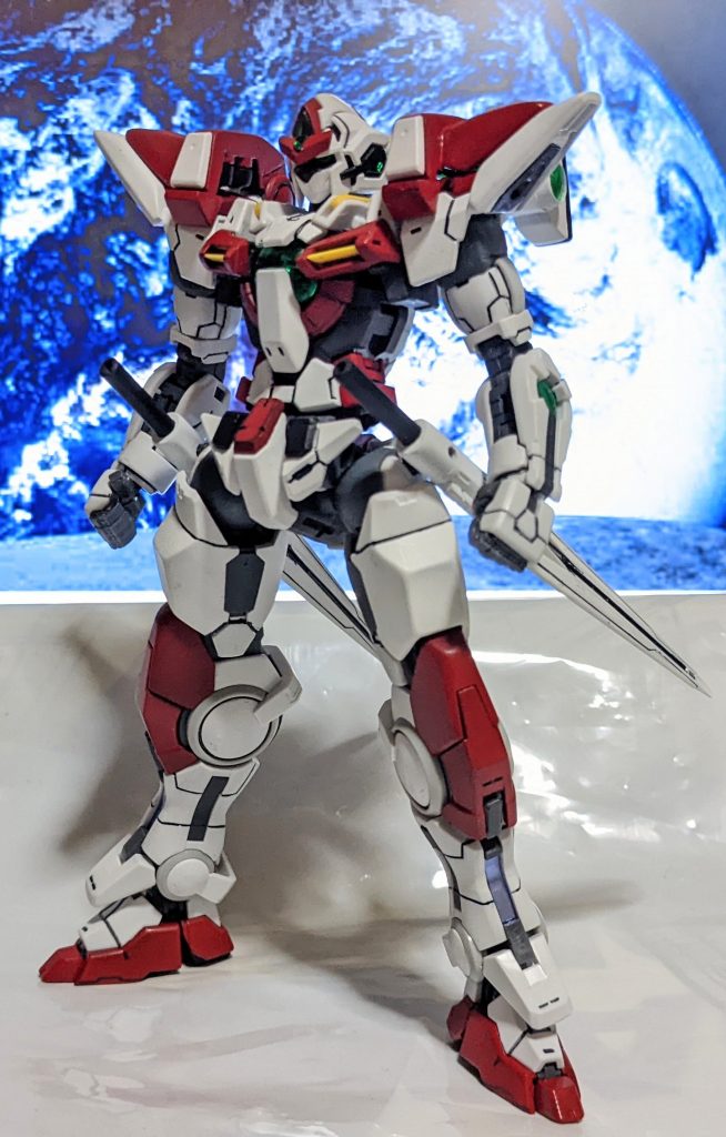 機体解説型式番号:OGN-001B名称:ガンダム・エクスブレードNAME:GUNDAM=EX-BLADEパイロット:マイケル・チャン(演:マモー・ミヤノ)武装GNブレードランサー×2 両腰に懸架したランサー。納刀時はウイングバインダーの役割を果たす。連結することでツインランサーにもなり、ビーム刃を形成してロングブレードにもできる。また、柄尻からビームを発振でき、高速戦で刀身がウイングバインダーの機能を果たしている場合はグリップを取り外してビームサーベルとして使用することもある。GNニードルマシンガン×2 両腕に内蔵されたビームマシンガン。射程と命中率が犠牲になった代わりにビームを針状に圧縮しているため速射力と貫通力を高めている。近〜中距離でばら撒くか、格闘戦で殴りつつ直接当てることが多い。クラッシュイントルード 全身に貯蔵された粒子エネルギーを開放することで最大1分間だけ3倍の機体スペックを発揮するトランザムシステムを応用した突撃技。機体正面にGNフィールドを展開した状態で高速移動しながら突撃を行うため、防御や移動にも用いられる。使用後は5分間のリキャストタイムが完了するまでクラッシュイントルードとボルテッカの両方が使えなくなる。ボルテッカ 両肩に搭載された必殺武装。トランザム1回分の莫大な粒子エネルギーを扇状に放射する。驚異的な威力の代償として、5分間のリキャストタイムが完了するまでクラッシュイントルードとボルテッカの両方が使えなくなる。P.E.Cキャノン 頭部クリスタルから放たれるビーム砲。粒子エネルギーは使用しておらず、マイケル曰く「気合で出してる。が、使うとかなり疲れる」らしい。恐らくイノベイターとして覚醒した彼のサイキックパワーのようなものと考えられる。威力にムラはあるが最大出力ならボルテッカに匹敵し、粒子エネルギーを使い切った際の切り札にもなる。ハイコート・ボルテッカ P.E.Cキャノンとボルテッカを同時に放つ超必殺技。拡散するボルテッカをP.E.Cキャノンに収束させることで、それぞれを単発で使用した攻撃力の合算からさらに2乗分の攻撃力となる。P.E.C.キャノンよりも精神的消耗が激しく、命に関わるため万全の状態でも1戦闘で1度しか使えない。