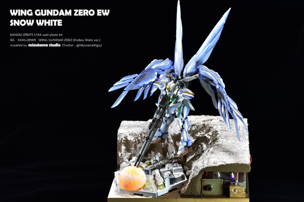 ジオラマベースには、MDF木材と発泡スチロールを用いています。ツインバスターライフルの爆撃雲は、ピンポン玉とΦ5mmの砲弾型LEDで電飾を施しました。LEDの駆動回路にはキャンドルライトICを使用することで、爆撃による光の揺らぎを表現しています。電源の最低構成は単3電池3本ですが、長期展示を行う関係で、今回は単1電池6本で構成しています。ジオラマ右下には赤外線センサーを搭載しており、人が近づくと各LEDが約30秒間点灯して自動消灯します。電源と自動消灯の工夫により、3ヶ月以上の連続稼働が可能となっています。