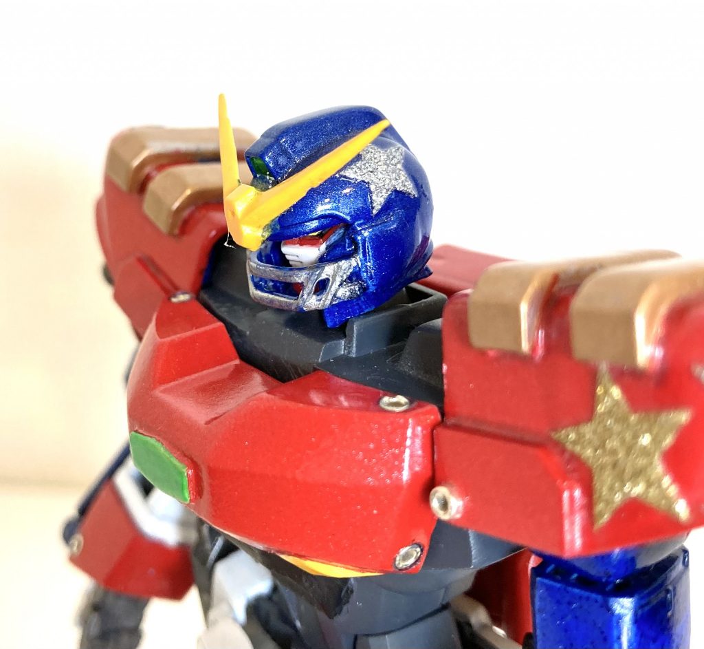 顔（フェイス部）はAGEのものに交換、アゴのフェイスガードは、アメフトのヘルメット風にプラ棒で新造しました（これだけはオリジナルです）。ヘルメットと肩アーマーには、100均の星形ラメシールを貼りました。90年代くらいのアメリカンな感じ（ロッキー３のジェームス・ブラウンのLive in Americaのイメージ）を出したかったのですが、どうでしょう。