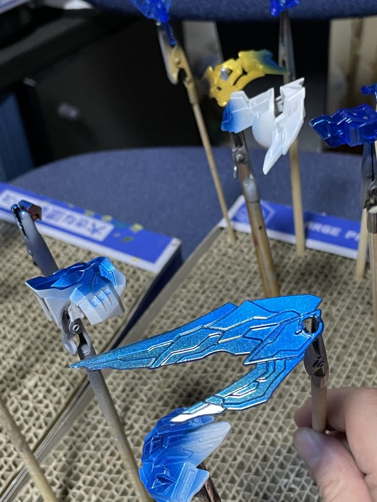 塗装自分用メモを兼ねて記載。今回はフリーダムということで、新発売された水性ホビーカラーのSEEDカラーを使いました。と言っても、ディアクティブブラックをほぼ下地色として使っただけですが😆断りのないものは水性ホビーカラーです。黒: ディアクティブブラック→つや消し白: ディアクティブブラック→ホワイト+ガンダムホワイト→つや消し青1: シルバー→クリアブルー (一部はさらに→アクリジョン 光沢クリア+VGエメラルド→光沢クリア)青2: ティターズブルー2→CCパールブルー→つや消しクリア赤: →ホワイト+ガンダムホワイト→ガンダムレッド→つや消し赤(筆塗り): シタデル メフィストレッド金: ディアクティブブラック→シルバー→クリアイエロー+クリアオレンジ金(筆塗り): シタデル リトリビューターアーマーグレー: ダークグレー+ニュートラルグレー (馬超作成時に調色したもの)スミ入れはMr. ウェザリングカラーのマルチグレー、マルチブラック、フィルタリングレッド水性ホビーカラーの上にアクリジョン(光沢系)を重ねる場合、下地の水性ホビーカラーが十分乾燥するのを待ってから重ねた方がいいですね。そうしないとアクリジョンの層が水性ホビーカラーの乾燥を妨げてしまうようです。約1日放置後にマスキングしたのに表面の光沢が死んでしまいました。おそらく内部が固まりきっておらず、マステを貼り付けた時に変形してしまったものと思われます😢オマケ