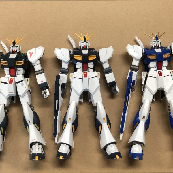 EGのνガンダム、喜び勇んでまずは素組みしたものの、うーむ。HGやRGなどと並べてみて、1番の違和感の原因はデカすぎるパンツとの結論に。ブカブカのトランクスを穿いたイケメンです、これは。ということで腰フロントアーマーをメイン写真にあるように中央付近に切断線を入れて、だいたい均等に削って幅詰めをしてみました。左が切断前で右が切断後。このパーツ、階段状なのでなかなかうまく削れないです、トホホ。まあ、とりあえず接着してパテで隙間埋めて塗装すれば目立たんだろうということで、様子見に福岡ガンダム風塗装でバランスを見てみました。左右で大きさがちょっと違うのはご愛嬌。(目分量あるあるです)（3枚目）