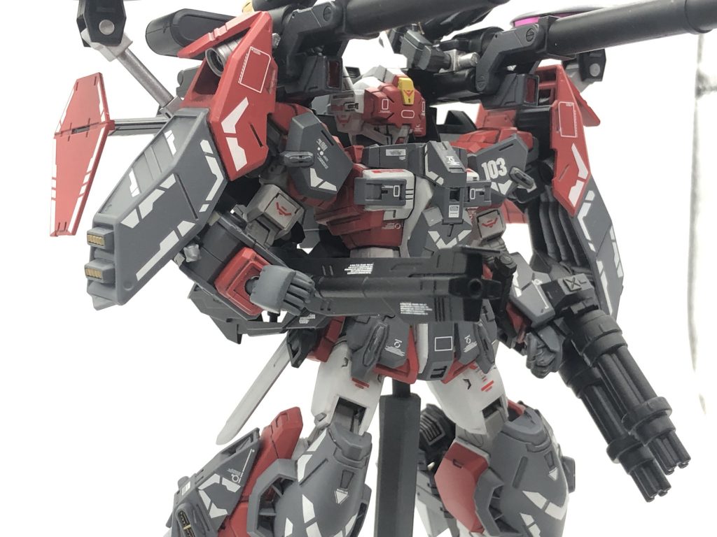 レールキャノン改修前と同兵装。バックパックにアームで接続されており、使用時は前方に展開して使用される。本機の全ての形態で使用可能な武装。