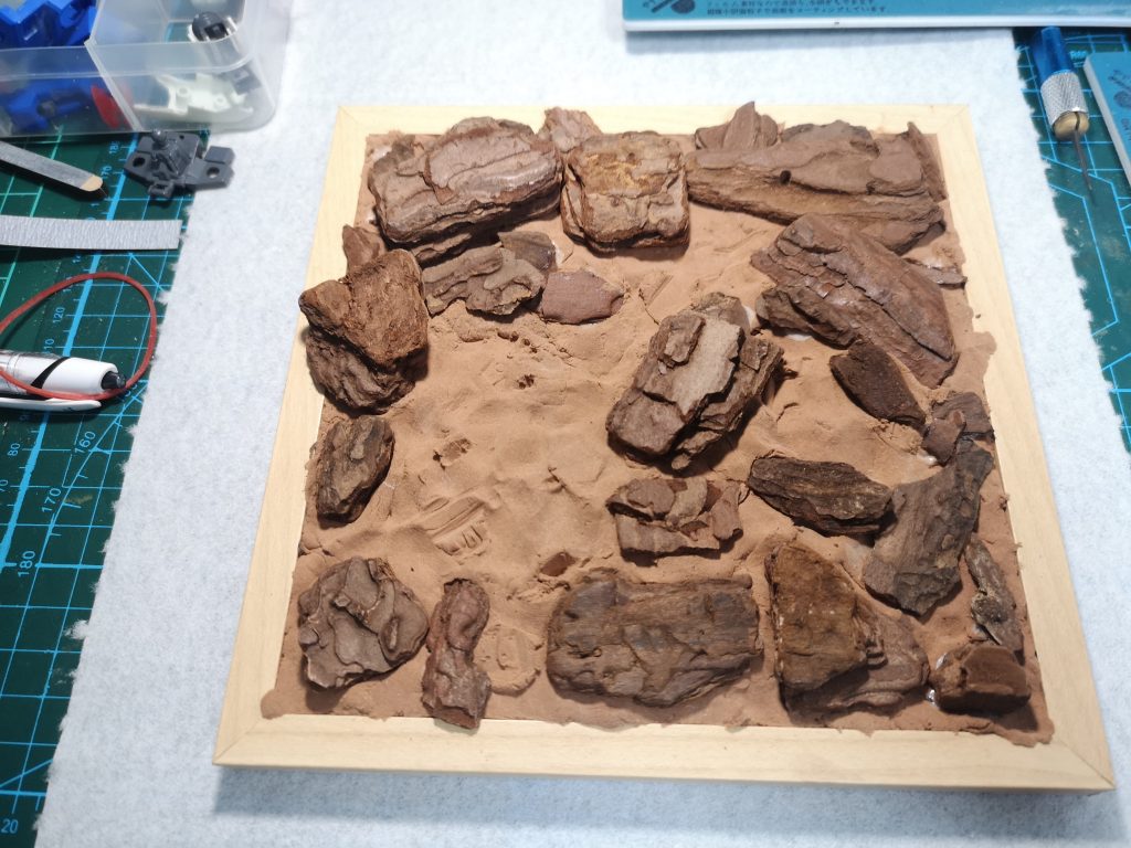 台座や岩、地面はすべて100均で揃えています。岩は園芸用のバークチップ、地面はふわっと軽いねんどを使用。接着は木工用ボンドを使っています。