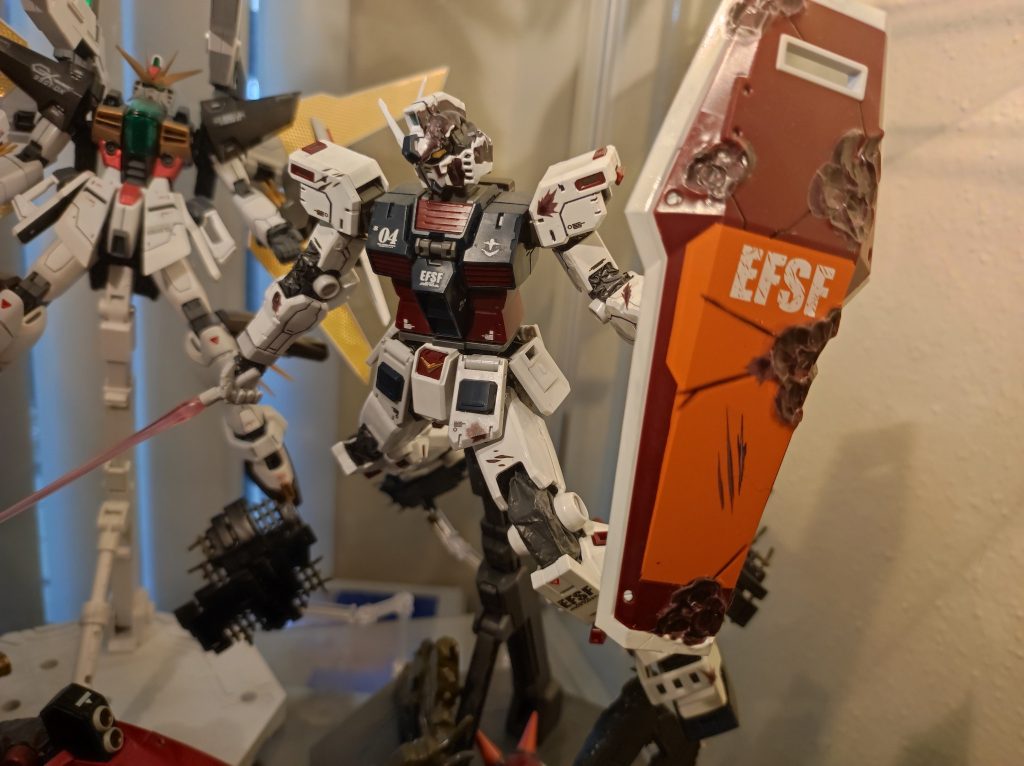 シールドのオレンジ色の部分は実、大きなデカールです。後ろのガンダムDXを無視してください、部屋は狭いなのです。