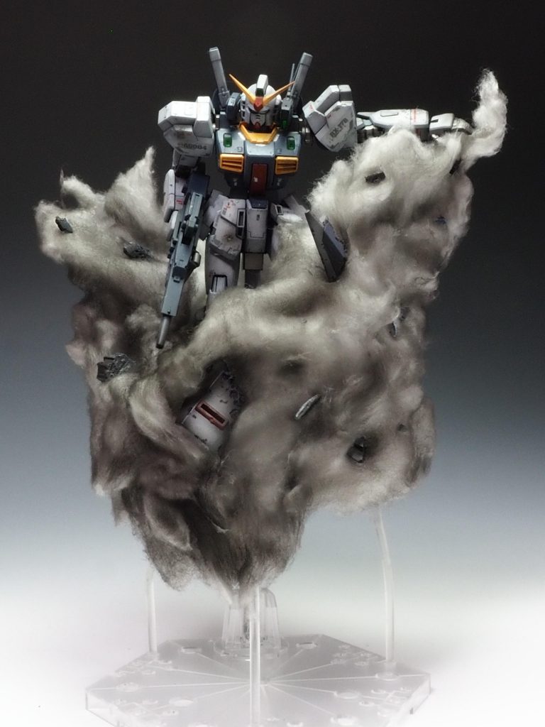 クリアープラ棒とクリアープラペーパーでベースを作り100均のコットンパフを貼付け煙に見立ててます。細かくバラしたHGガンダムmk2のシールドを貼付けグラファイトブラックで塗装しました。RGのシールドはもったいなくて壊せませんでした💦