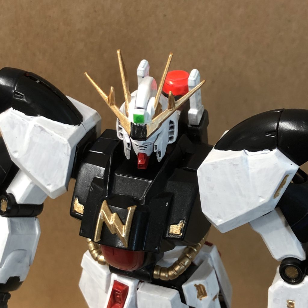 アンテナ抑えになっている額パーツは使わずに、アンテナパーツの本体側を一部カットして垂直面を作っています。そこをセンサに見立てて蛍光塗料で緑に。本来のνガンダムだと逆五角形のパーツでアンテナ抑えになっていますが、そこは塗装でなんとなくそんな感じのパーツがあるように見せています。胸のマークは90度回転させて一部カットして『N」マークに。