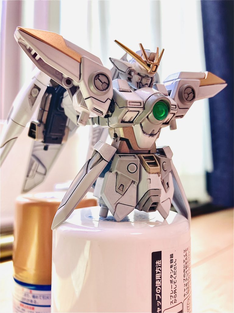塗装2クレオス　Mr.カラースプレー　S-9ゴールドクレオス　ガンダムスプレー　UG05 MSグレｰ連邦系タミヤ　エアーモデルスプレー　TS-87 チタンゴールドアンテナと肩の部分をクレオスのゴールドで塗りました。腹筋部分や、股間（？）上部はタミヤのチタンゴールド。チタンゴールドはその他にも関節やフレームの部分をこれで塗りました。メタルビルドのスノーホワイトを参考に配色しました。大体イメージ通りの色に塗れました。塗装開始の後にスミ入れして、デカールを貼り付けました。デカールはウイングゼロのデカールが手に入らなかったので、RGフォースインパルスのものを使用しました。表面処理は光沢クリアーで仕上げました。テッカテカでツルツル！