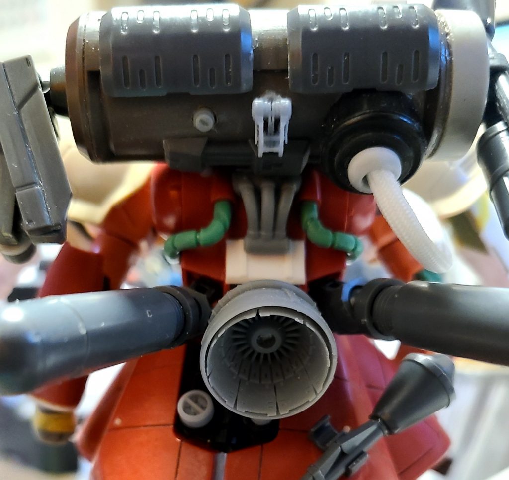 追加のバックパック(タンク)に見立てたガルバルディリベイクのバックキャノンから伸びる白いメッシュパイプ(画面右上)との接続基部()には、自身の自転車に取り付けていたスマホホルダーの部品を加工しました。メインのバーニアは、フォロワーさん版はコトブキヤさんのものでしたが、手元にあった、AUBE DIMENSIONWORKSさんのものにしてみました。別パーツとして側面に付くはずの三連パイプが余ってしまったのですが、勿体ないのでその上部に取り付けてみました。