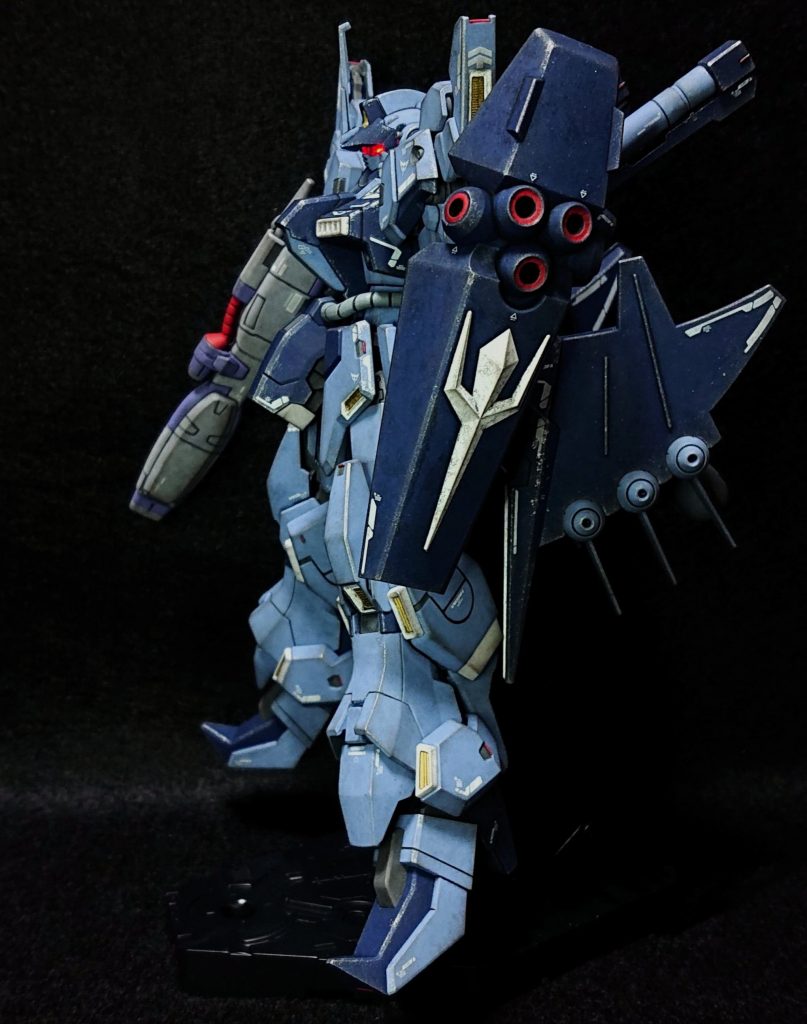 本体の部分塗装は説明書では白黒で細かい色が分からなかったので、商品ページを確認しながら、肩・スネ部・プロペラントタンク基部をクレオス328番のブルー、装甲表面の凹モールド・可動時に見えそうな装甲裏面・合わせ目を消したプロペラントタンクをクレオス602番のグレー、バーニアとビームガン砲口をクレオス28番の黒鉄色、赤熱化するダクトとその縁はマッキーのペイントマーカーのゴールドとホワイトで塗装しました。初めてペイントマーカーを使用しましたが、ゴールドはムラなく塗れて非常に使い易かったです。ホワイトはインクの量の調整が難しかったですが、他の塗料の筆塗りよりムラが出にくく、細かな塗装には便利でした。ただシールドのネオジオンマークだけは面積が広く凹凸が多くてムラが出そうだったので、マスキングして缶スプレーの白サフとホワイトで塗装しました。