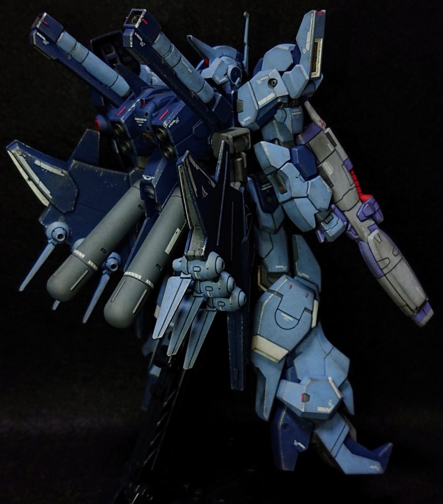 シールドのメガ粒子砲の縁とハイパーナックルバスターのスコープのケーブルはクレオスGX3番のレッド、ハイパーナックルバスターの塗り分けはガイアノーツのエヴァパープルグレーで塗装しました。ディテールアップはガンダムデカールのRGサザビーの水転写デカール(唯一の1/144サイズのネオジオン軍機のデカール)を貼り、アドラーズネスト超極細リード線の赤でレッドポイントを付け、つや消し後にウェザリングカラーのブラックでのウォッシング、水性アクリジョンのシルバーでのチッピング、最後にウェザリングカラーのガンメタルで黒立ち上げ風に仕上げました。また、細かいポイントで1つ前の写真に写っていますが、左肩側面にパイロットのクロエの階級である中尉の階級章のデカールを貼っています。