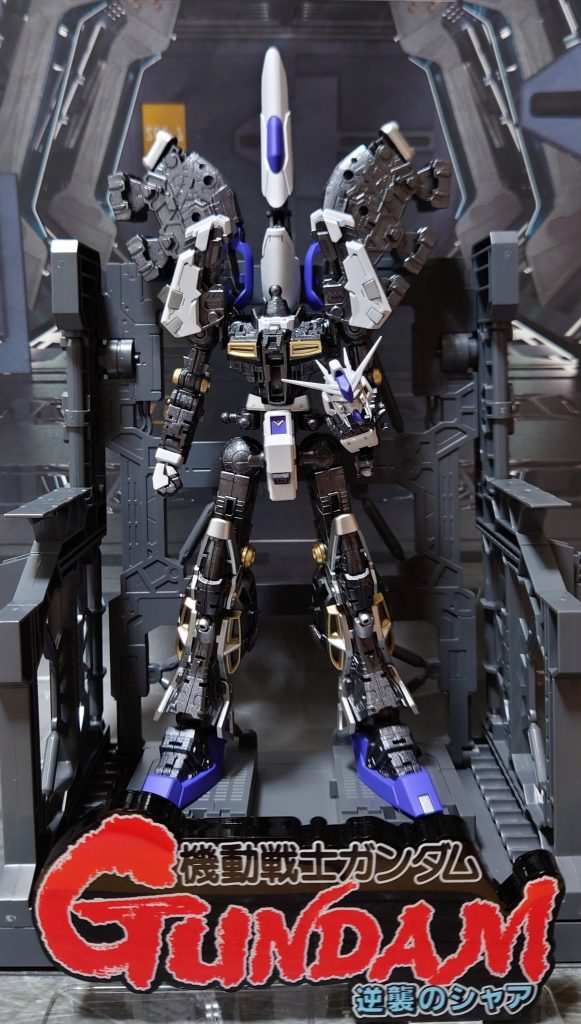 新型のガンダムを建造中のシーン、からタイトルロゴがドン!と被さるイメージ。