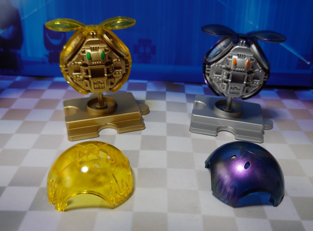 ■黄色い方外装をクリアイエロー、内部メカと台座をゴールドに塗装。カメラアイはゴールドの上からフィニッシュシートのクリアグリーンを貼り付け。トップコートは光沢。腕と脚は墨入れとつや消しのみ。■メタリックパープルの方外装を、クリアが残るようにダークブルーで塗装後、偏光パープル/グリーンで塗装。カメラアイはシルバーリーフの上からガンダムマーカーのメタリックオレンジ。内部メカとその他の箇所はシルバーリーフで塗装。トップコートは全て光沢。