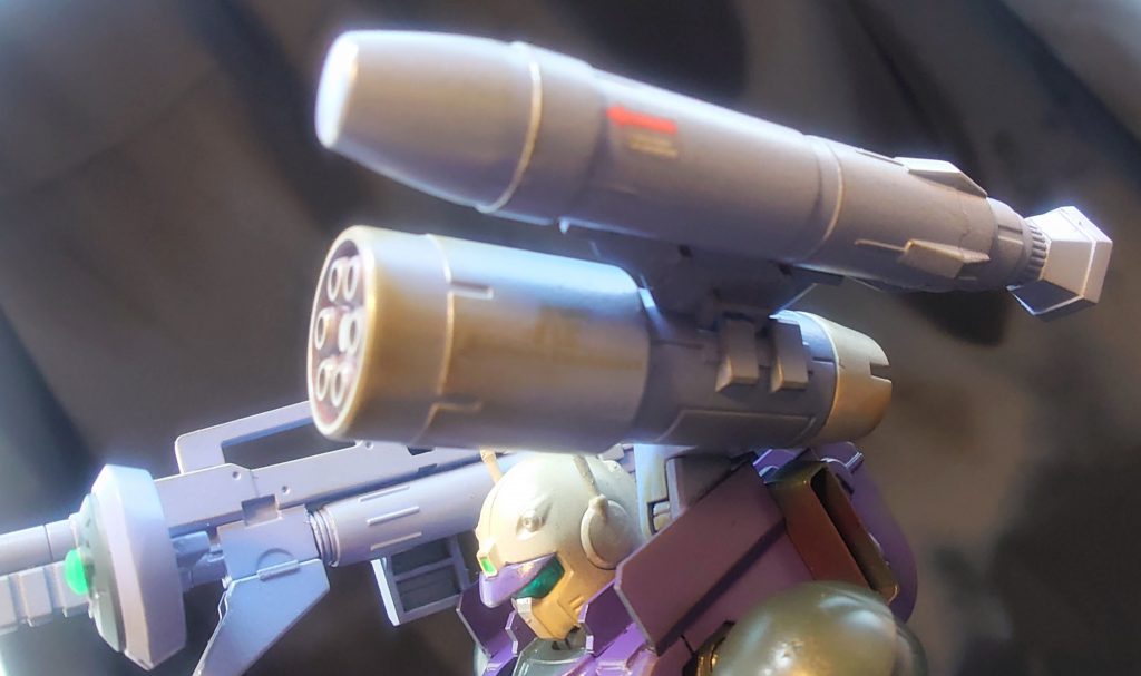 左肩は戦況に応じてスプレーミサイルポッドの他、写真のような６連装ガトリングに加え、単発の大型ミサイルを搭載している。これはソロモン攻略戦において多大な功績(と犠牲)をあげたパブリク突撃艇にも搭載されている「ビーム攪乱幕弾」をモビルスーツ用にリサイズしたもので、一個小隊で同時運用すれば広範囲においてメガ粒子砲等の影響を最小限に抑えることが可能であり、本機の性能を生かした戦闘が可能となりえる。