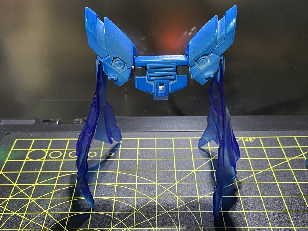 マントのバックパックは「ガンダムフェニーチェリナーシタ」のものに同機の肩パーツを接続しています。マントの色は本来ならばクリアピンクですが、林プロの色変えテクニックを使用してクリアブルーに塗り替えました。マントにはシャインシルバーを数回吹いて煌めきを加えています。