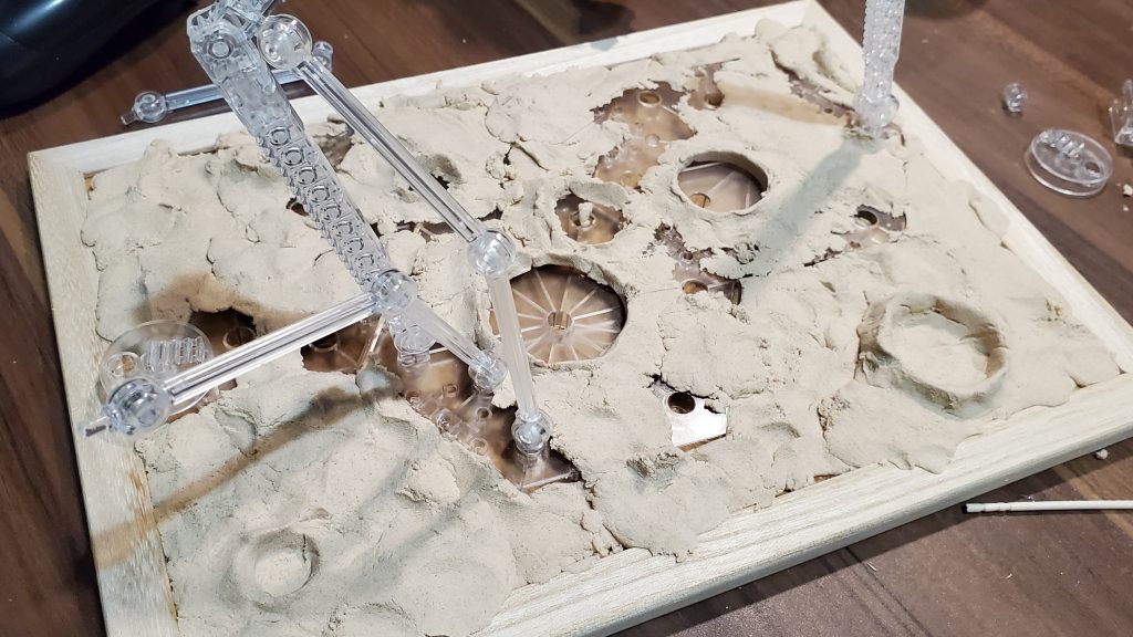 アクシズ風台座の制作風景100均のコルクボードの上にアクションベース4を置いて、上から木かる粘土を敷いてます