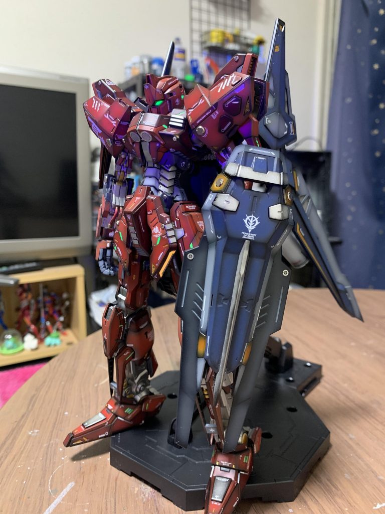 ・顔のツインアイにはシールではなくて目の形にカットしたプラ板をマスキング代わりにして蛍光塗料とブラックで作成しました。その後にクリアブラックでグラデーションをかけています。なのでブラックライトの距離によっては目の大きさが変わります。この写真はブラックライトを近めで当てているので機体がブラックライトで紫色に見えてしまっていますね。。